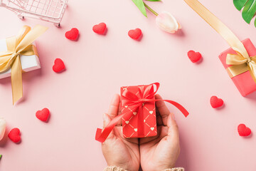 Woman hands holding gift or present box decorated and red heart surprise