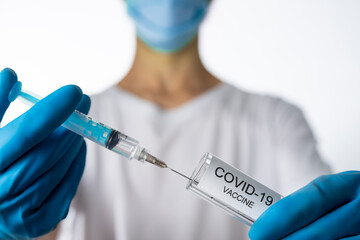 Doctor filling syringe with coronavirus covid-19 vaccine. on white background