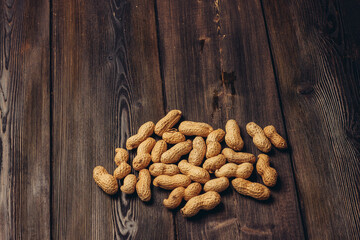 scattered peanuts in shells on a wooden table top view beer snack