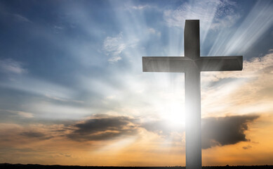 The cross with the sunset background was lit by the setting sun.