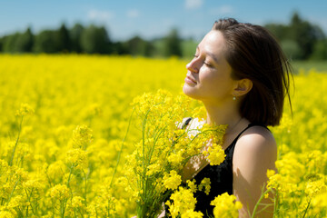 Naklejka na ściany i meble happy girl dreams of a yellow rapeseed field in summer
