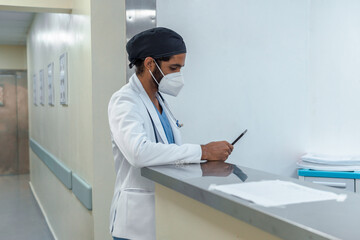 Doctor checking his tablet in the corridor of a hospital