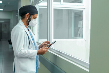 Naklejka na ściany i meble Doctor checking his tablet in the corridor of a hospital
