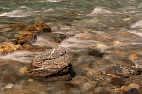 Closeup of a clear, fast-running stream rushing over its bouldery bed. Makarora River, Mount Aspiring National Park, Otago, New Zealand.