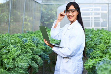 The female botanist, geneticist, or scientist is working in a nursery full of plants.