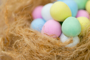 Easter image with Close Up Colorful Egg Chocolates on the Nest with Copy Space
