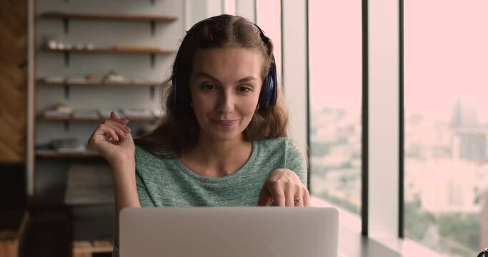 Confident young female teacher in headphones giving educational online lecture to students, successful business lady holding video call meeting with colleagues or client, distant communication concept