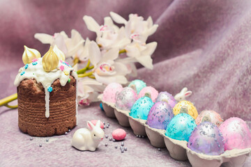 Special easter cake Kulich with the remit and dyed eggs. Cosmos painted eggs with white rabbits. Easter composition