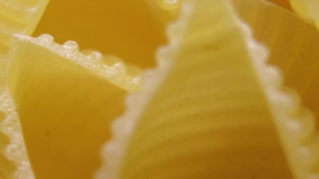 Pasta for food, rotation. Macaroni - Mini Conchiglie Rigate close up.