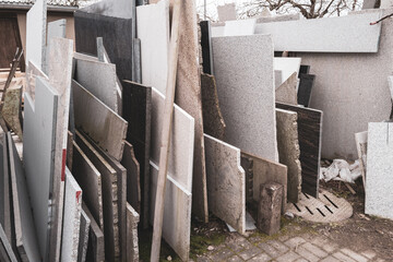 in a courtyard of a stonemason's workshop there are many different granite and marble slabs...