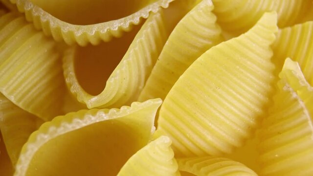 Pasta for food, rotation. Macaroni - Mini Conchiglie Rigate close up.