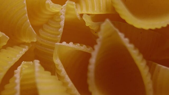 Pasta for food, rotation. Macaroni - Mini Conchiglie Rigate close up.