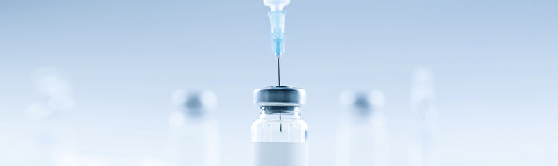 Medical syringe with a needle and a bollte with vaccine.