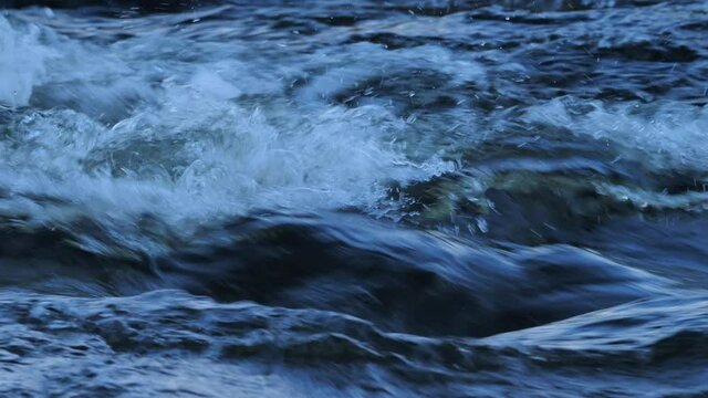 Closeup detailed footage of water flowing through rapids on a river in Northumberland, England