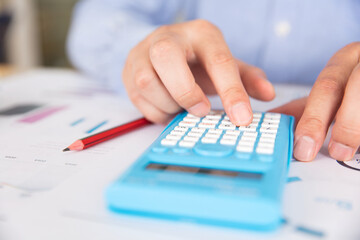 Obraz na płótnie Canvas An accountant using a calculator