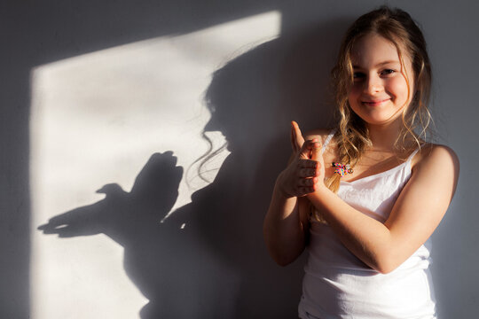 Girl shows dove symbol that she folded with her hands