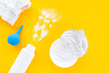 Set of children's cosmetics on a yellow background, top view, copy space, mockup. Baby hygiene, trendy minimalistic background. Flat lay composition diaper, powder, cream