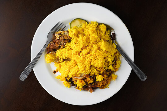 Yellow Rice With Slice Of Cucumber, Shrimp Paste And Anchovies On White Plate With Spoon And Fork, Top View