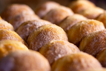 close up of a pile of doughnut with icing sugar 