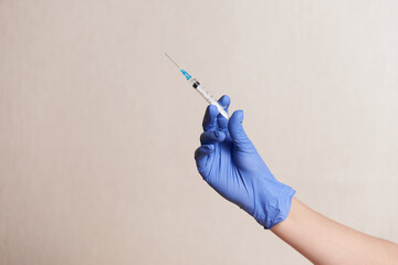 a woman holds an injection syringe in front of her. Vaccination in a pandemic