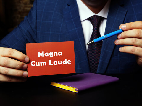 Blank red business card with inscription Magna Cum Laude in person hand. Horizontal shot. Close-up