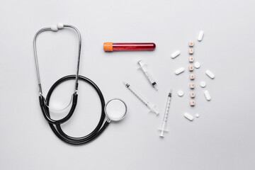 Word DIABETES, stethoscope, syringes, blood sample and pills on grey background