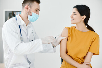 caring doctor in protective gloves to stick the injection to a woman covid vaccination