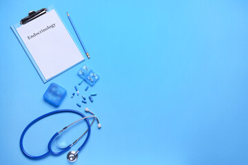 Clipboard with word ENDOCRINOLOGY, stethoscope and pills on color background