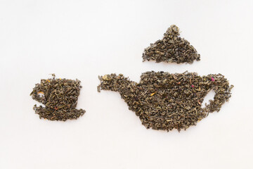Cup and teapot made of dry tea leaves on white background