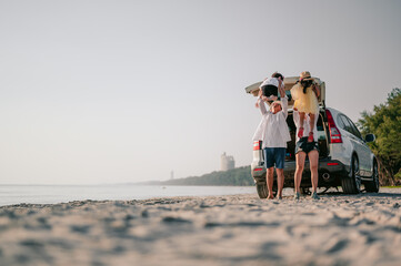 Asian family vacation holiday, Happy family running on the beach in the sunset.Parents holding their children.Concept family and Holiday and travel.