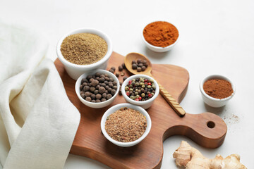 Board with different spices on white background