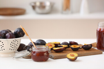 Glass jar with delicious homemade plum jam on table