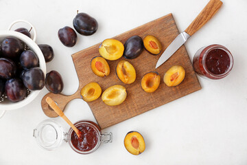 Composition with delicious homemade plum jam on white background