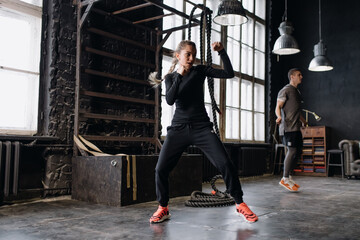 Fototapeta premium cool female fighter in boxing gloves trains in the gym. Mixed martial arts