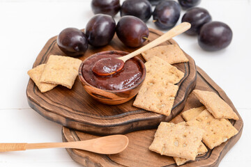 Composition with delicious homemade plum jam on wooden background