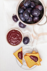 Composition with delicious homemade plum jam on white background