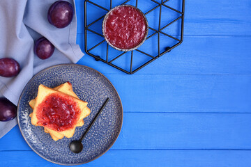Composition with delicious homemade plum jam on wooden background