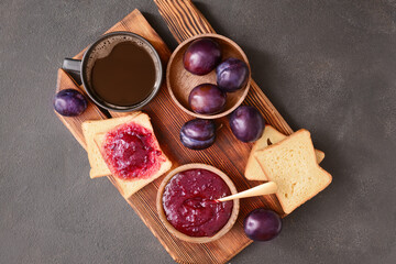 Composition with delicious homemade plum jam on dark background