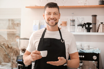 Barista with cup of hot espresso in cafe