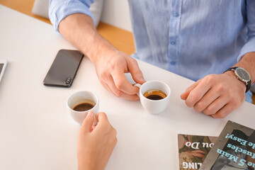 Happy couple drinking hot espresso on romantic date in cafe