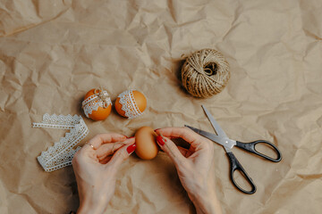 Decorating easter eggs on kraft paper with lace and rope. Three easter eggs on kraft paper...