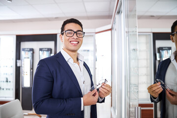 Smiling customer holding stylish spectacles in his hands