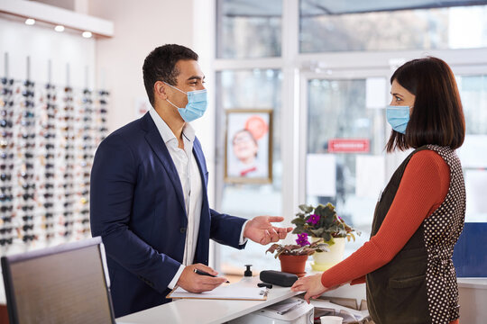 Customer In A Face Mask Talking To An Optometrist