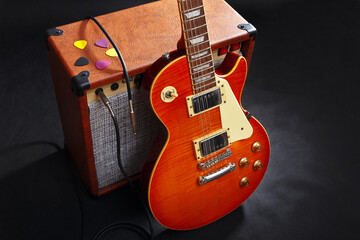Fototapeta premium Tube combo amplifier for guitar with guitar on black background.