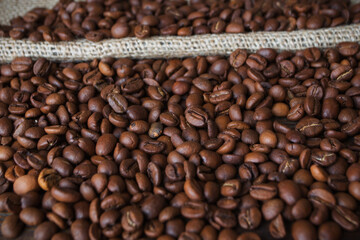 Obraz premium Background of coffee beans. Roasted coffee beans on a wooden table.
