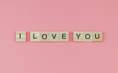 flat lay of wooden letters I  LOVE YOU on pink background. Valentine's day concept.
