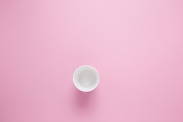 Paper cup for hot coffee or tea on a pink isolated background.