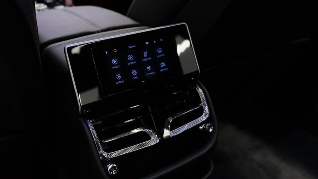Touchscreen control panel for all basic functions of passengers in the cabin of a luxury car. Closeup cinematic 4k shot