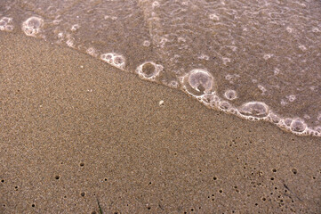 Sea surf, waves rolls on a sandy beach