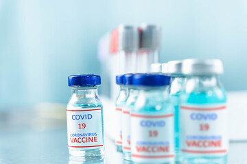 Obraz premium close up a vaccine bottle put on the table from the scientific laboratory, a concept of drug use to treat and protect the global COVID-19 pandemic